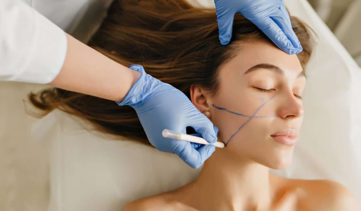 Closeup portrait beautiful woman during cosmetology procedures, rejuvenation in beauty salon. Dermatology procedure , painting eyebrows, hands in blue glows, at work, healthcare, botox.