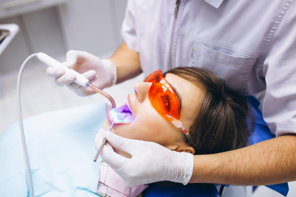 A dentist offering a laser teeth whitening treatment