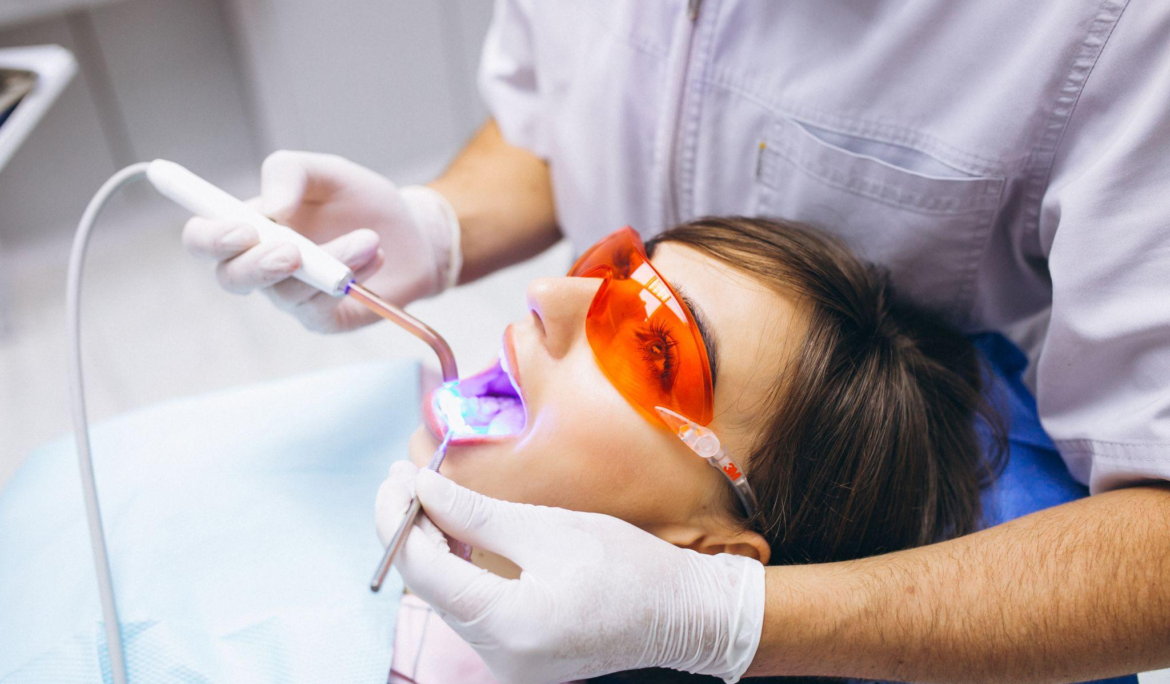 A dentist offering a laser teeth whitening treatment