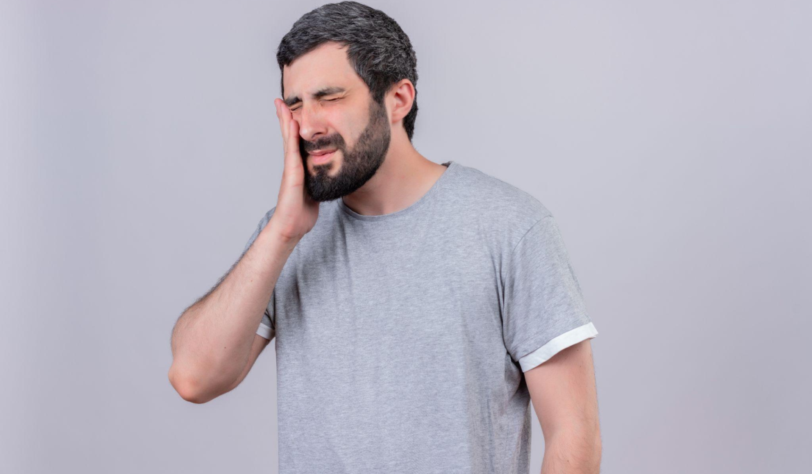 man holding his jaw tightly because of the pain