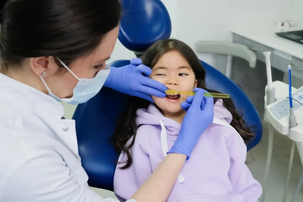 Dentist teaching child toothbrushing