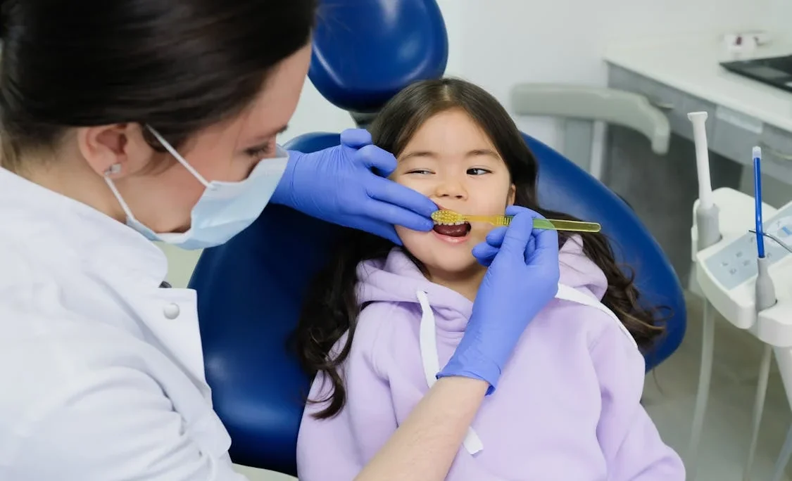 Dentist teaching child toothbrushing